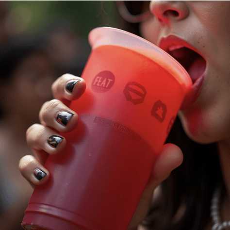 A colour-changing thermochromic CupLink cup, red and orange, being drunk from.
